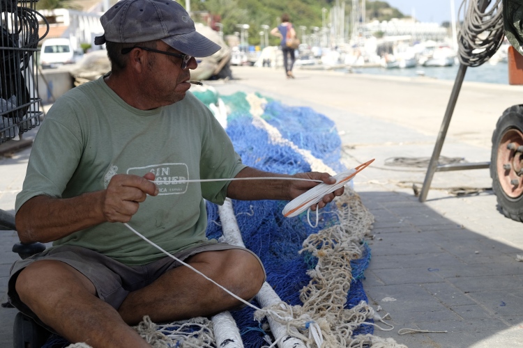 Man with cigarette mending net Mahon